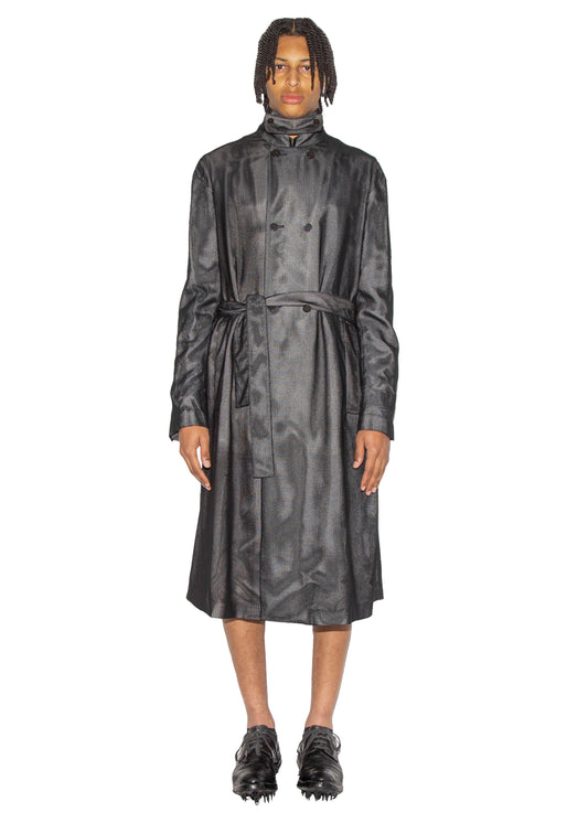 Person wearing a black leather trench coat on a white background