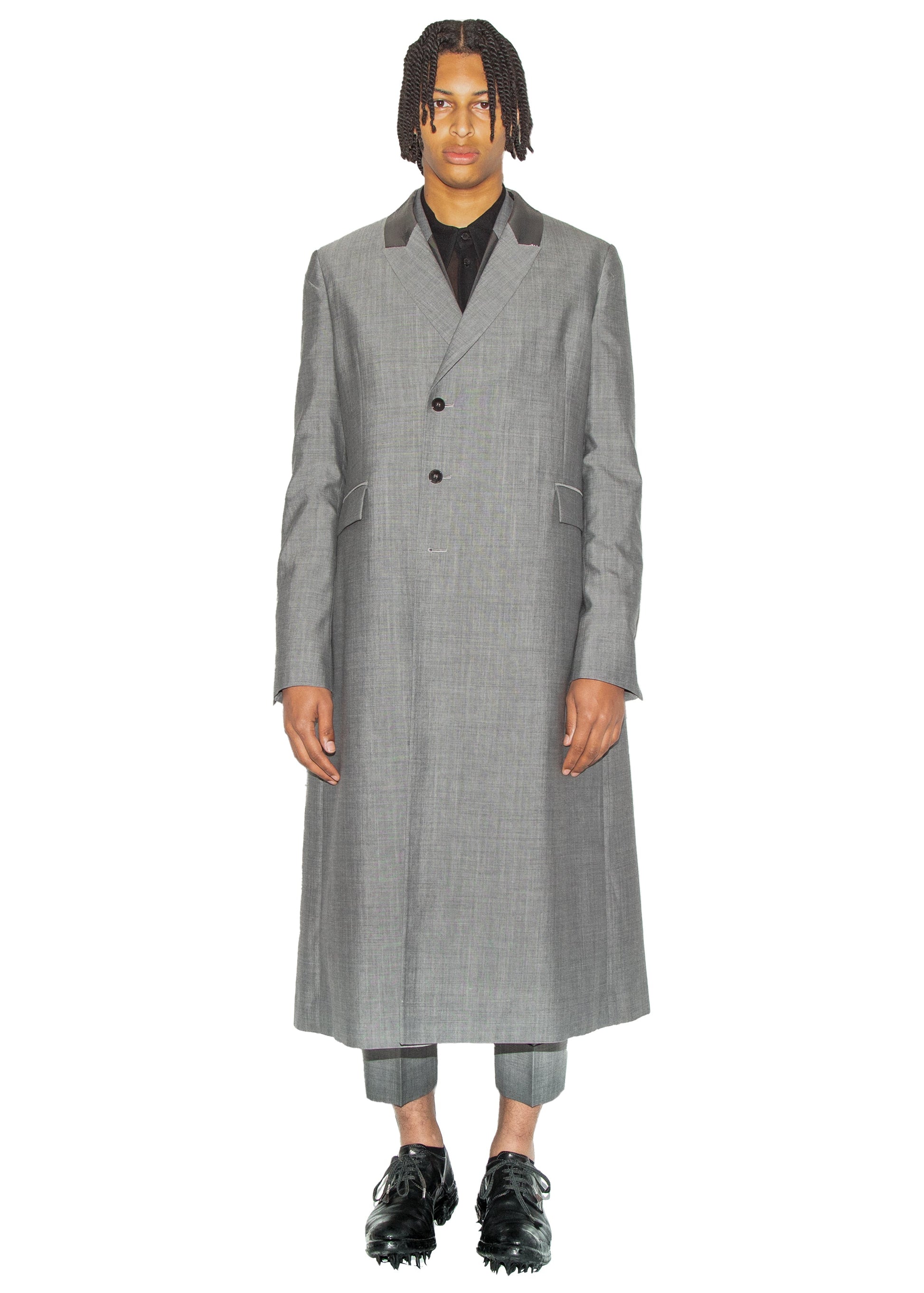 Man wearing a long gray coat on a white background