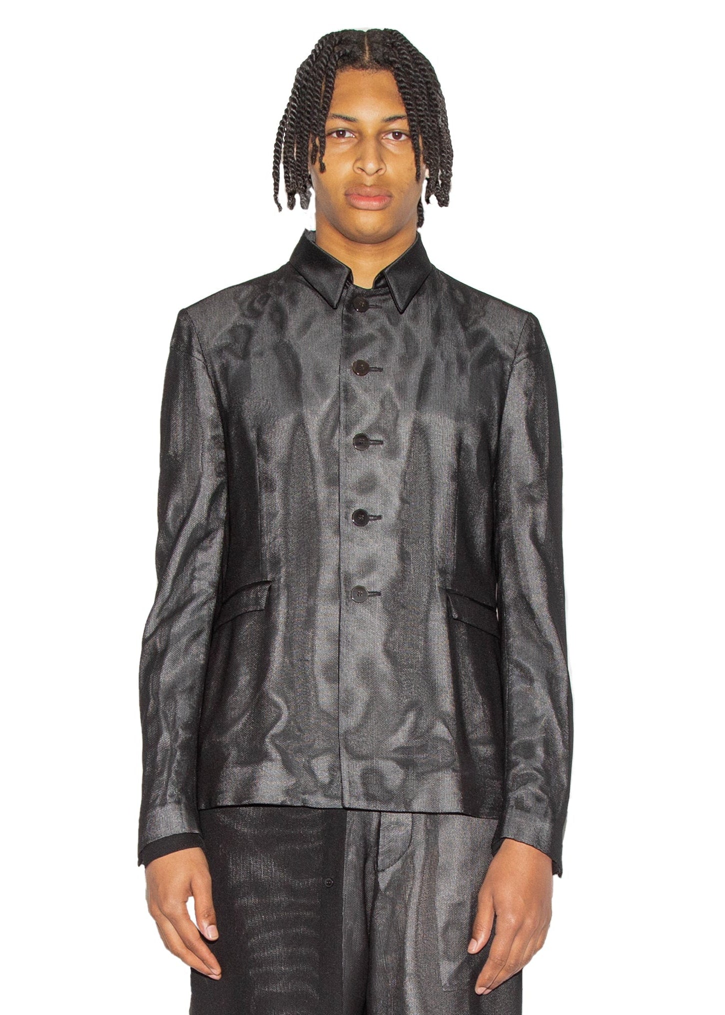 Person wearing a black textured jacket and shorts on a white background